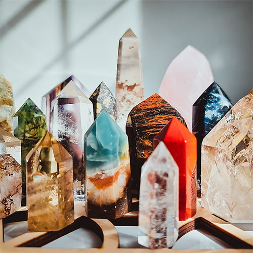 A table with lots of different size of crystal towers with the sunlight from the right sie
